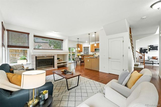 a living room with furniture a fireplace and a large window