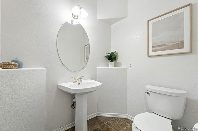 a bathroom with a toilet a sink and a mirror