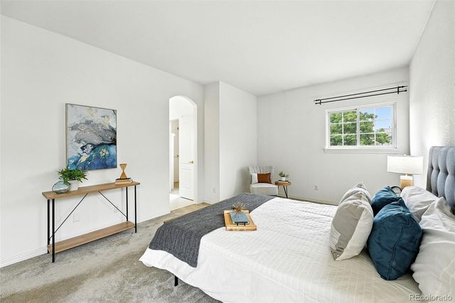 a bedroom with a bed and a painting on the wall