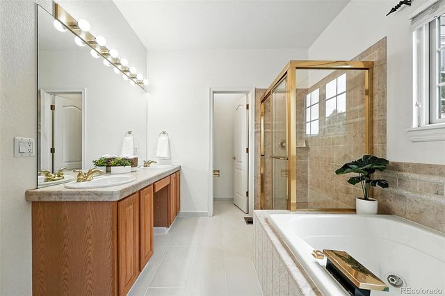 a bathroom with a granite countertop tub sink and mirror