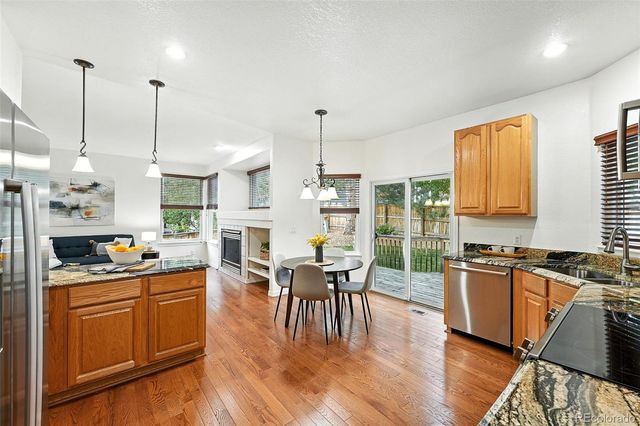 a kitchen with stainless steel appliances granite countertop wooden floors stove top oven and sink
