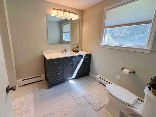 a bathroom with a toilet sink and mirror
