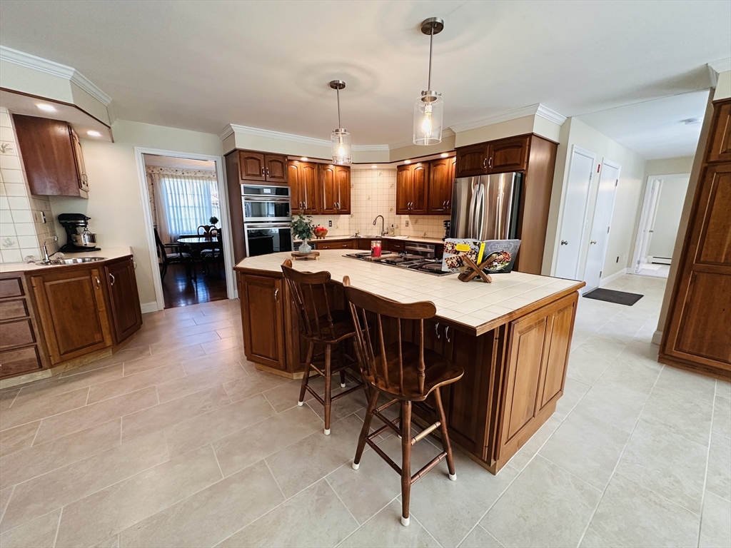 1107 Jackson Road Hardwick, MA 01037 - Photo 7 of 42 a open kitchen with stainless steel appliances granite countertop a stove a refrigerator a sink a dining table and chairs with wooden floor