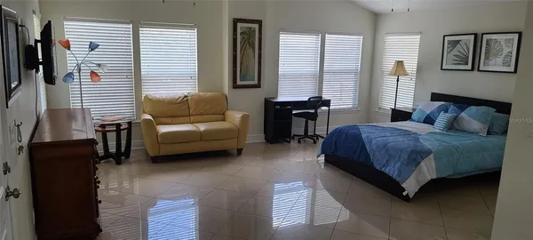 a bedroom with a bed and a couch next to a window