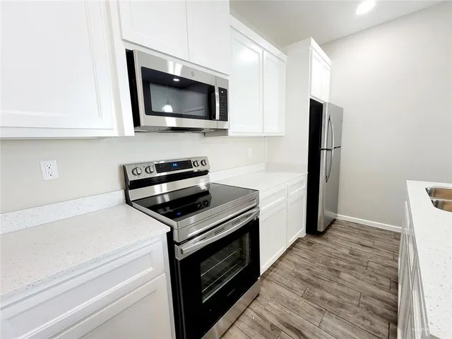 a kitchen with stainless steel appliances a stove microwave and sink