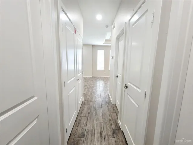 a view of a hallway with wooden floor and staircase