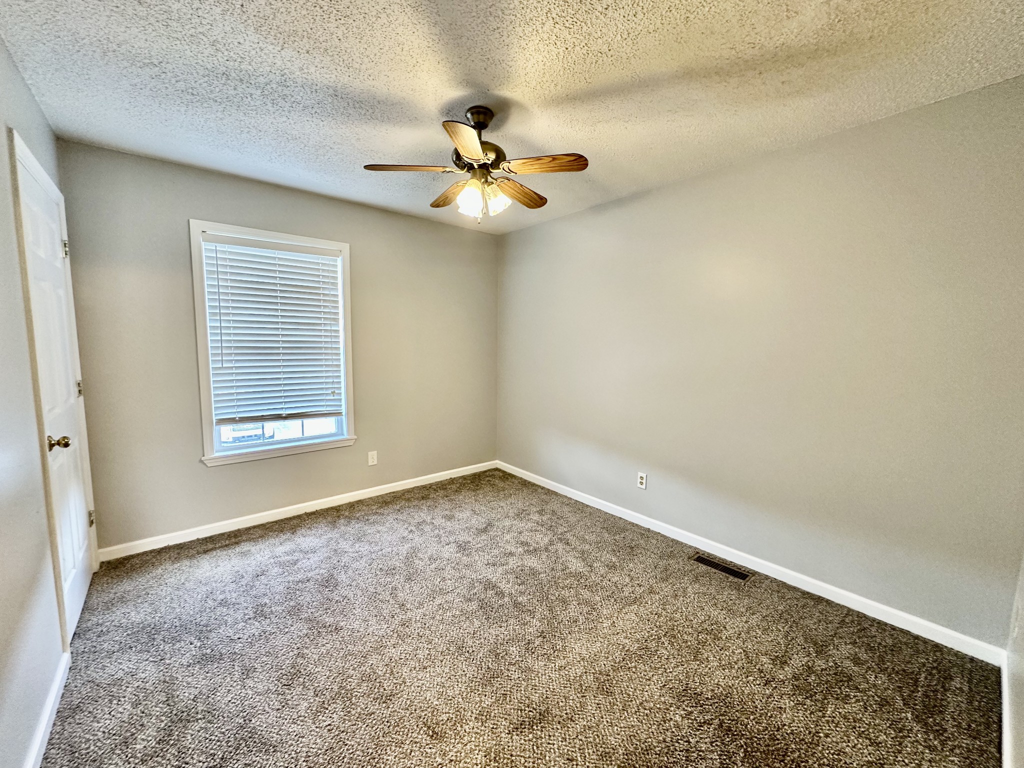 282 Raleigh Drive, Unit B Clarksville, TN 37043 - Photo 13 of 15 en empty room with windows and chandelier fan