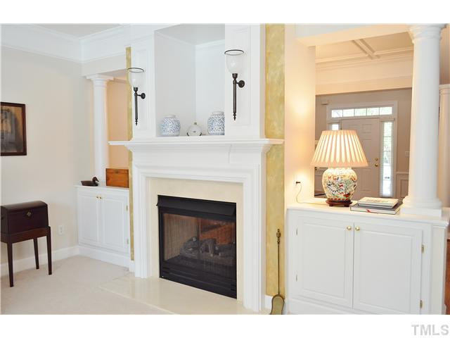 A closer view of this spectacular fireplace and the detailed moldings, columns and cabinetry that separates the family room from the formal dining or sitting room and foyer area. Other