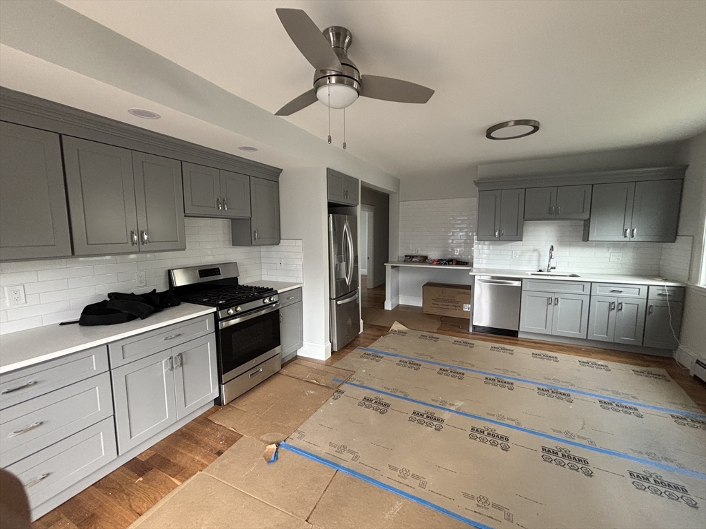 61 Waverly Street, Unit 2 Boston, MA 02135 - Photo 2 of 8 a kitchen with stainless steel appliances granite countertop a sink stove and refrigerator