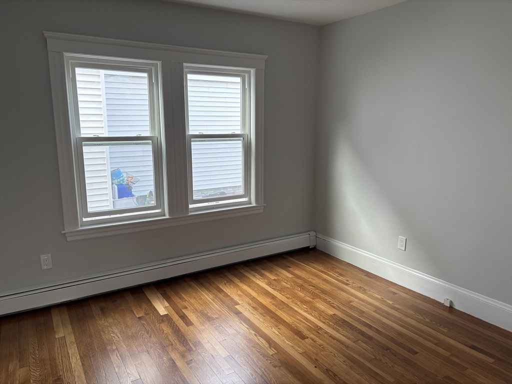 61 Waverly Street, Unit 2 Boston, MA 02135 - Photo 6 of 8 a view of an empty room with wooden floor and a window