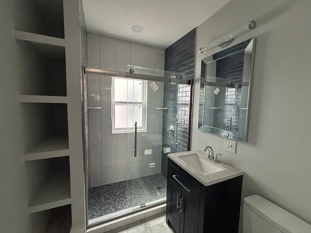 a bathroom with a sink a toilet and shower