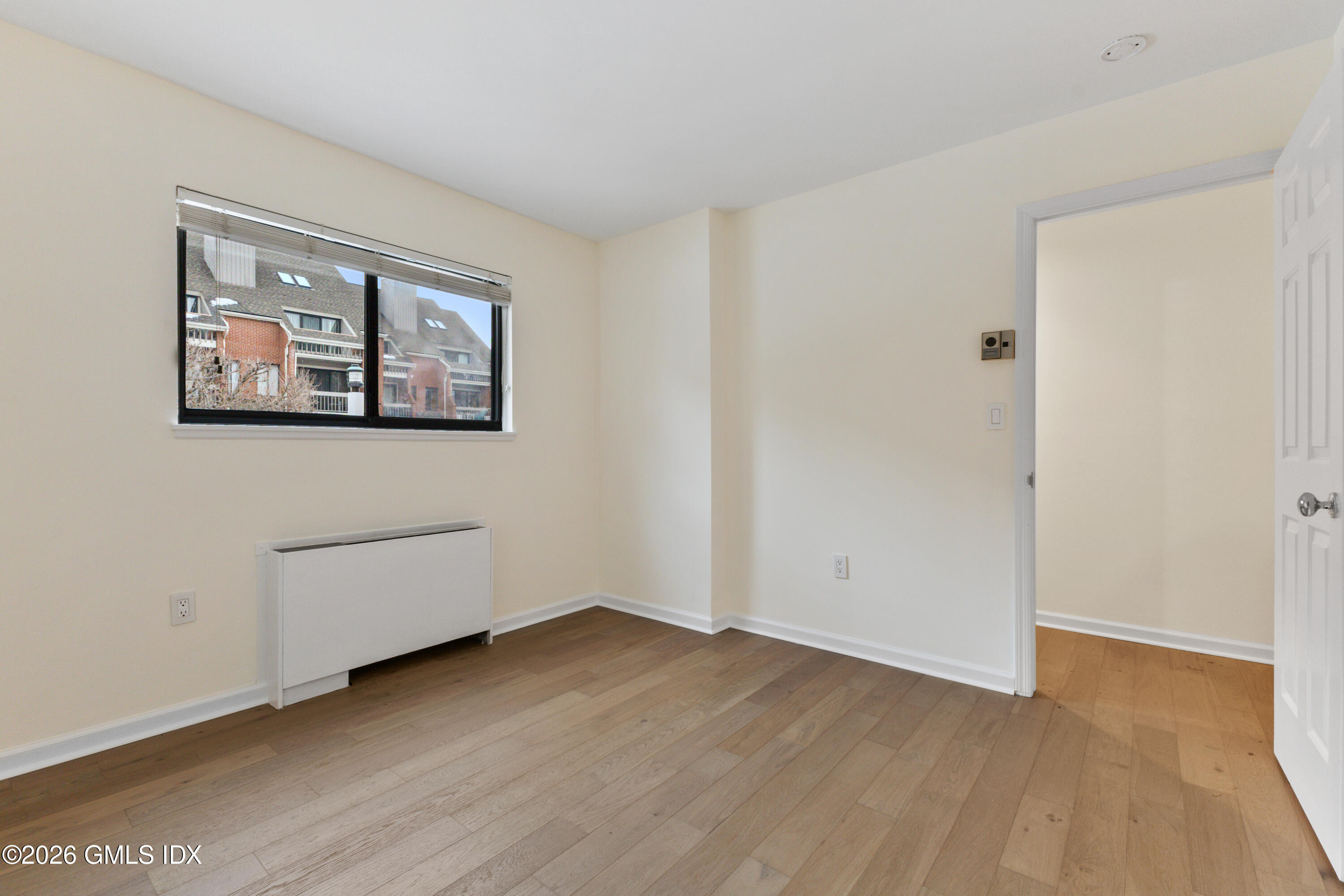 15 River Road, Unit 210 Cos Cob, CT 06807 - Photo 13 of 23 an empty room with wooden floor and window
