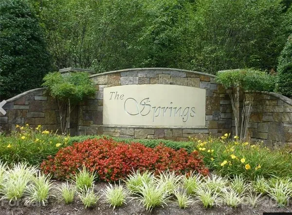 a sign that is sitting in front of flowers