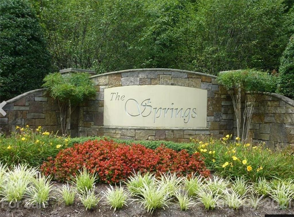 a sign that is sitting in front of flowers