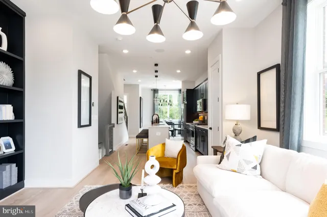 a living room with furniture a large window and stainless steel appliances