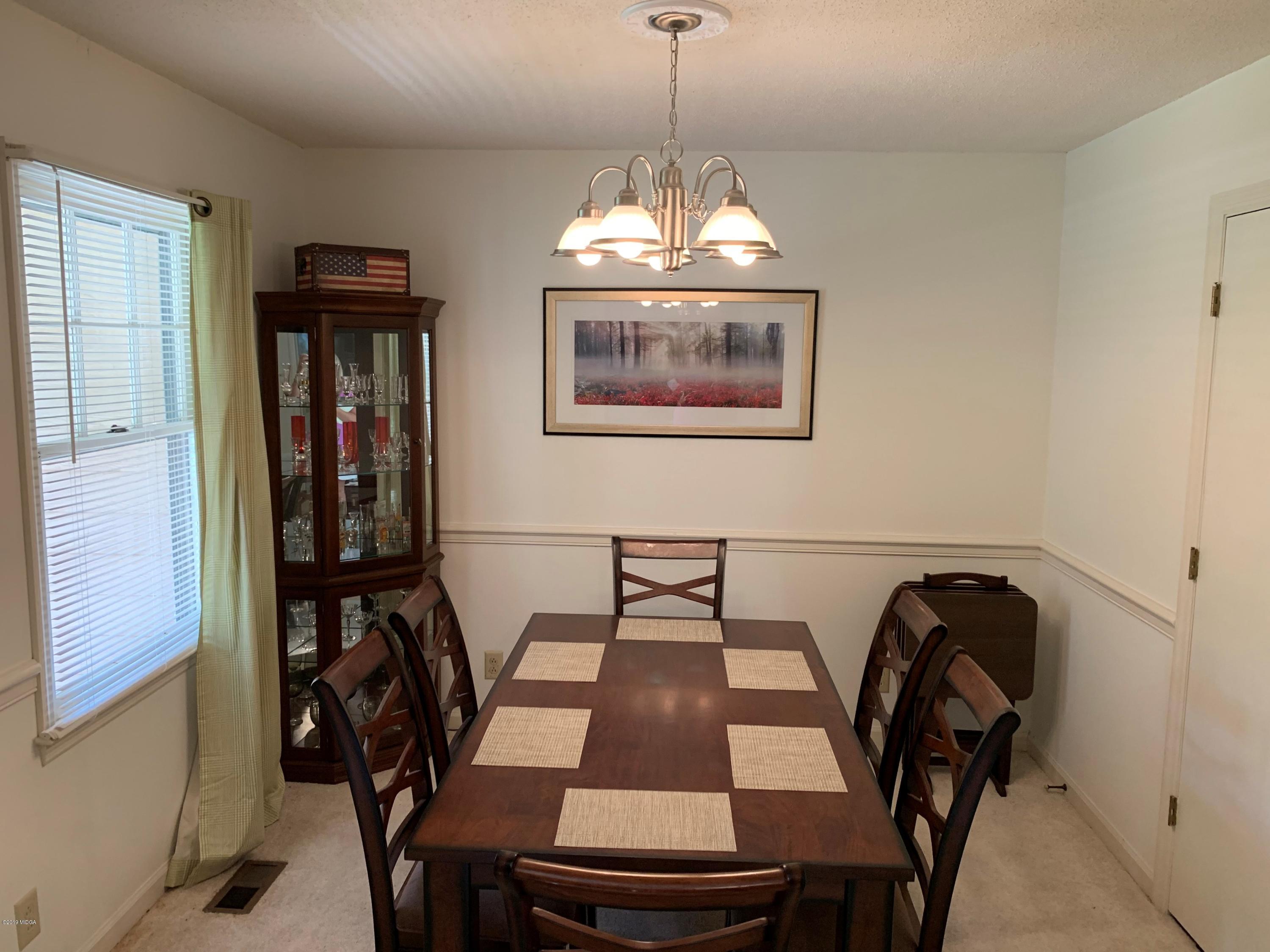 3295 Hartley Bridge Road Macon, GA 31216 - Photo 6 of 11 a view of a dining room with furniture and wooden floor