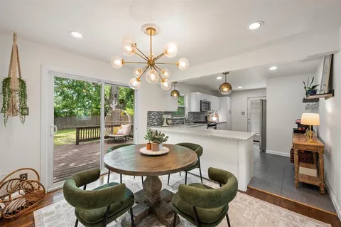 a kitchen with stainless steel appliances granite countertop a table and chairs