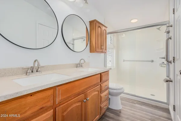 a bathroom with a double vanity sink mirror and toilet