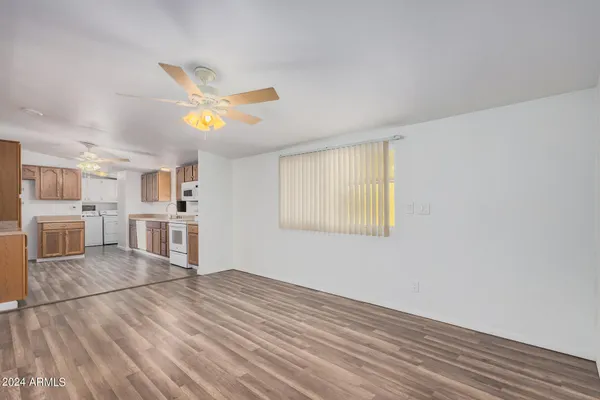 a view of a kitchen with wooden floor and a ceiling fan