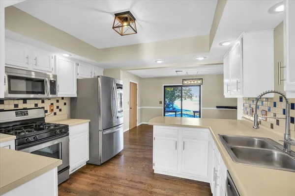 a kitchen with granite countertop a refrigerator stove and sink