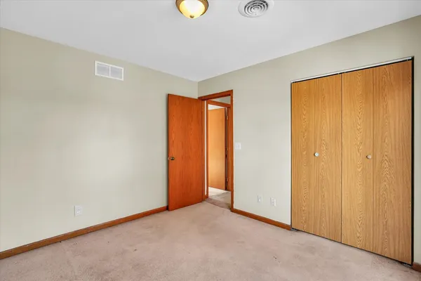 an empty room with windows and closet