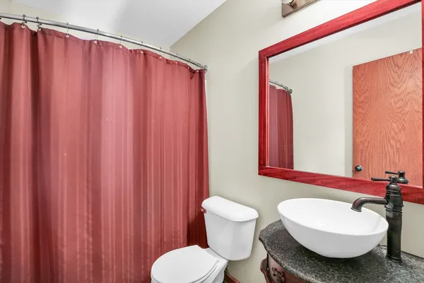 a bathroom with a sink toilet and shower curtain