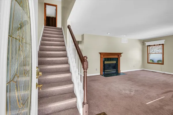 a view of a hallway with staircase and a fireplace