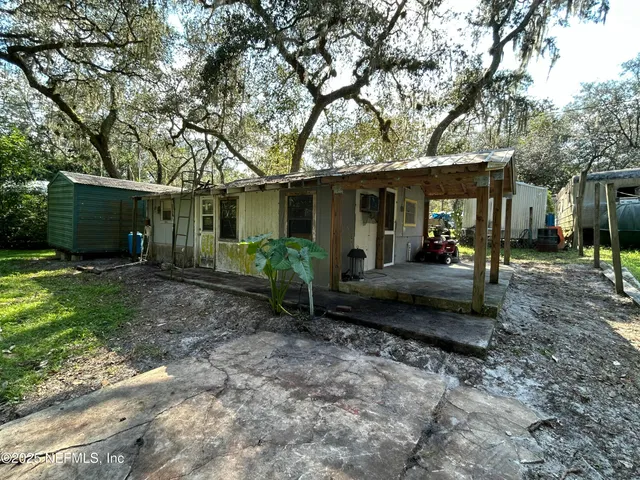 a view of a house with backyard and sitting area