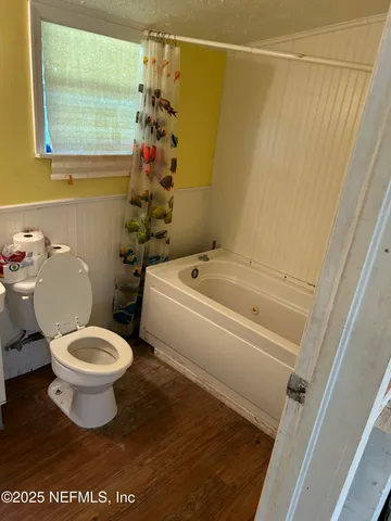 a white toilet sitting next to a bath tub