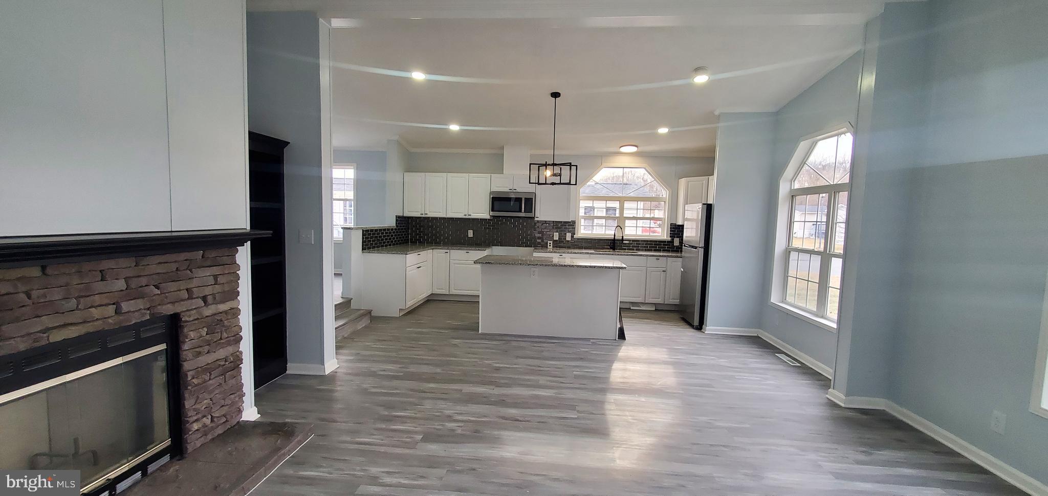 a large kitchen with cabinets and wooden floor