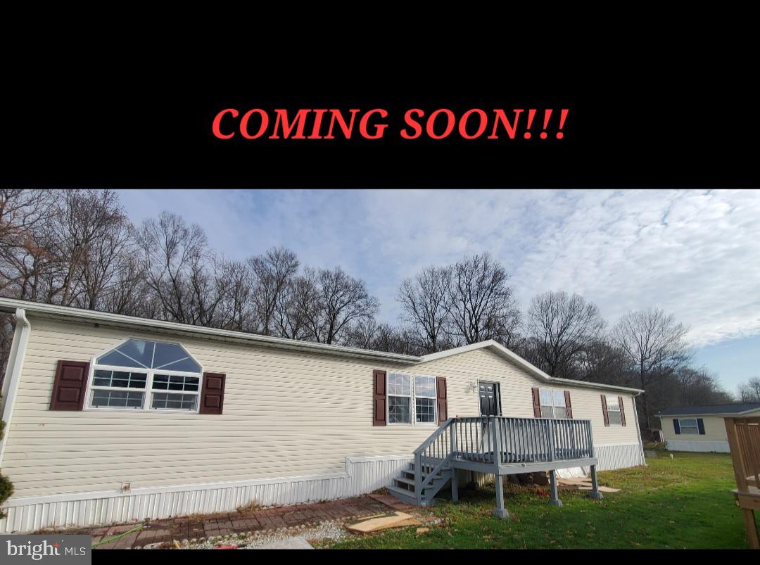a view of house with yard and sitting area