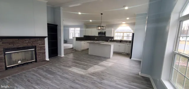 a open kitchen with a sink a fireplace and a stove top oven