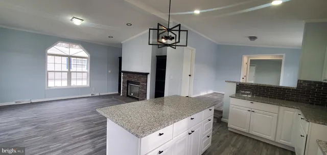 a kitchen with granite countertop a stove a sink and a refrigerator