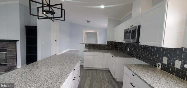 a kitchen with granite countertop a sink a stove and cabinets