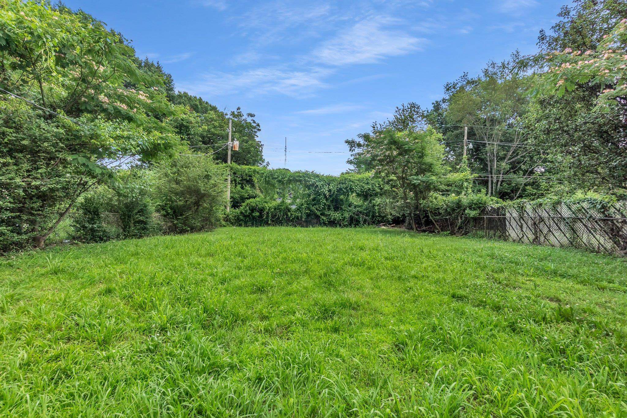 3186 Alta Road Memphis, TN 38109 - Photo 13 of 14 Expansive grassy yard with mature perimeter trees and a partial fence