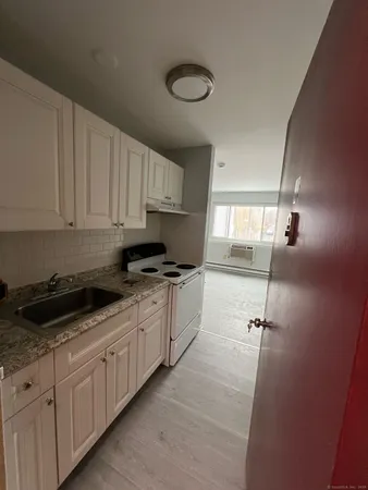 a kitchen with granite countertop white cabinets and white appliances