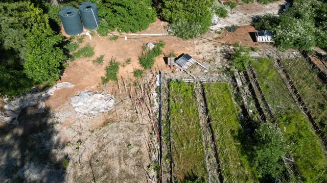 an aerial view of residential house with outdoor space and trees all around