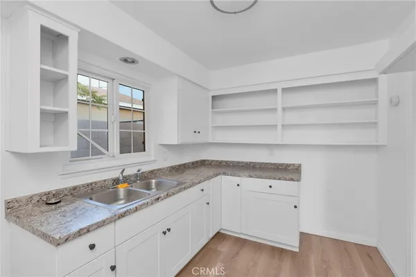 a kitchen with granite countertop white cabinets and a sink