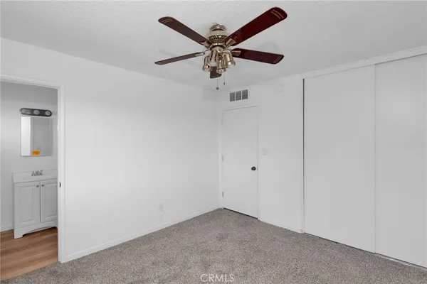 an empty room with closet and ceiling fan