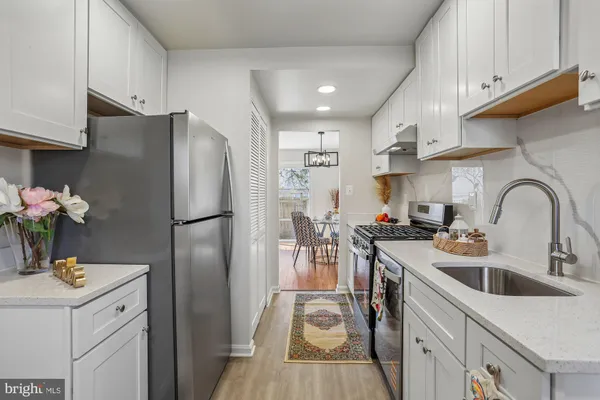 a kitchen with stainless steel appliances a sink a refrigerator and a stove