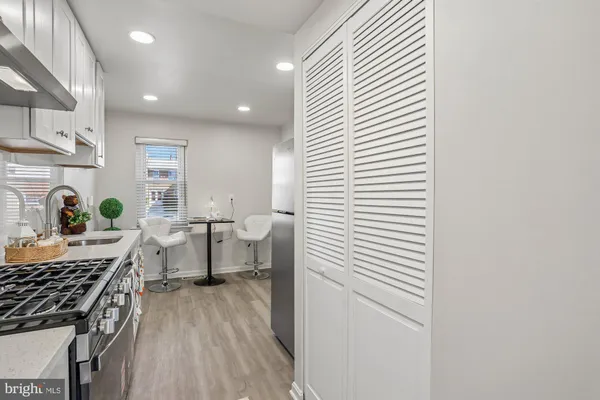a kitchen with stainless steel appliances granite countertop a sink stove and white cabinets