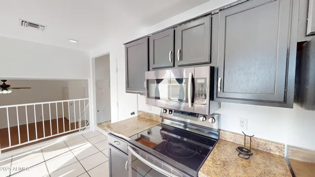 a view of a kitchen with stainless steel appliances granite countertop a refrigerator and a stove top oven