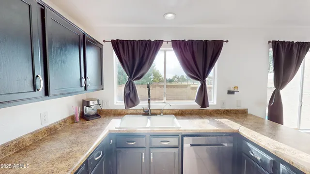 a kitchen with kitchen island granite countertop a sink and a stove