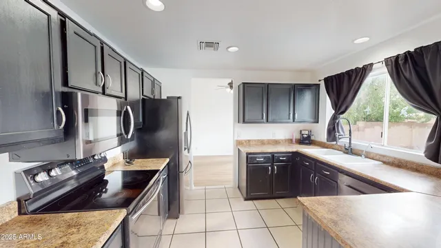 a kitchen with stainless steel appliances granite countertop a sink stove and refrigerator