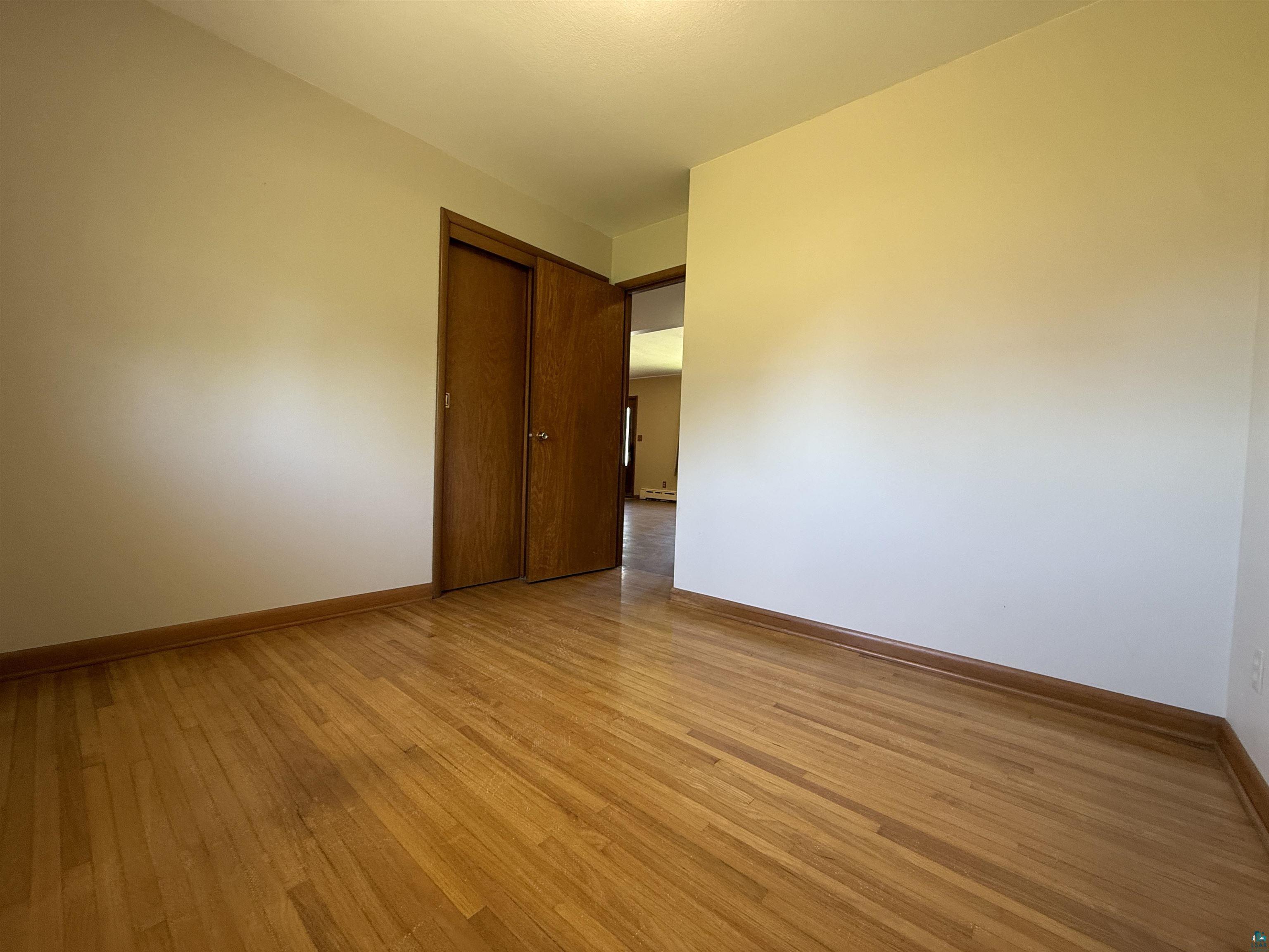607 3rd Street Northeast Chisholm, MN 55719 - Photo 18 of 32 Hardwood flooring throughout this room features natural wood tones and a glossy finish