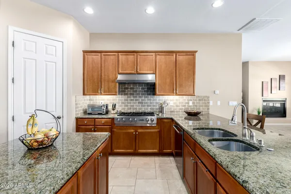 a kitchen with kitchen island granite countertop a sink stove and cabinets