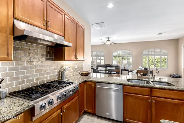 a kitchen with a stove a sink a window and cabinets