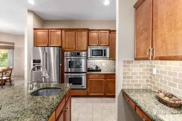 a kitchen with granite countertop a sink stove and refrigerator