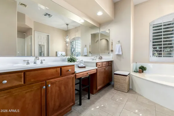 a spacious bathroom with a double vanity sink a large mirror and a bathtub