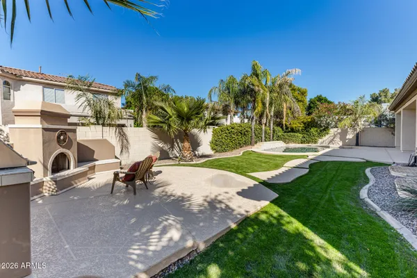 a view of a backyard with couches plants and large tree